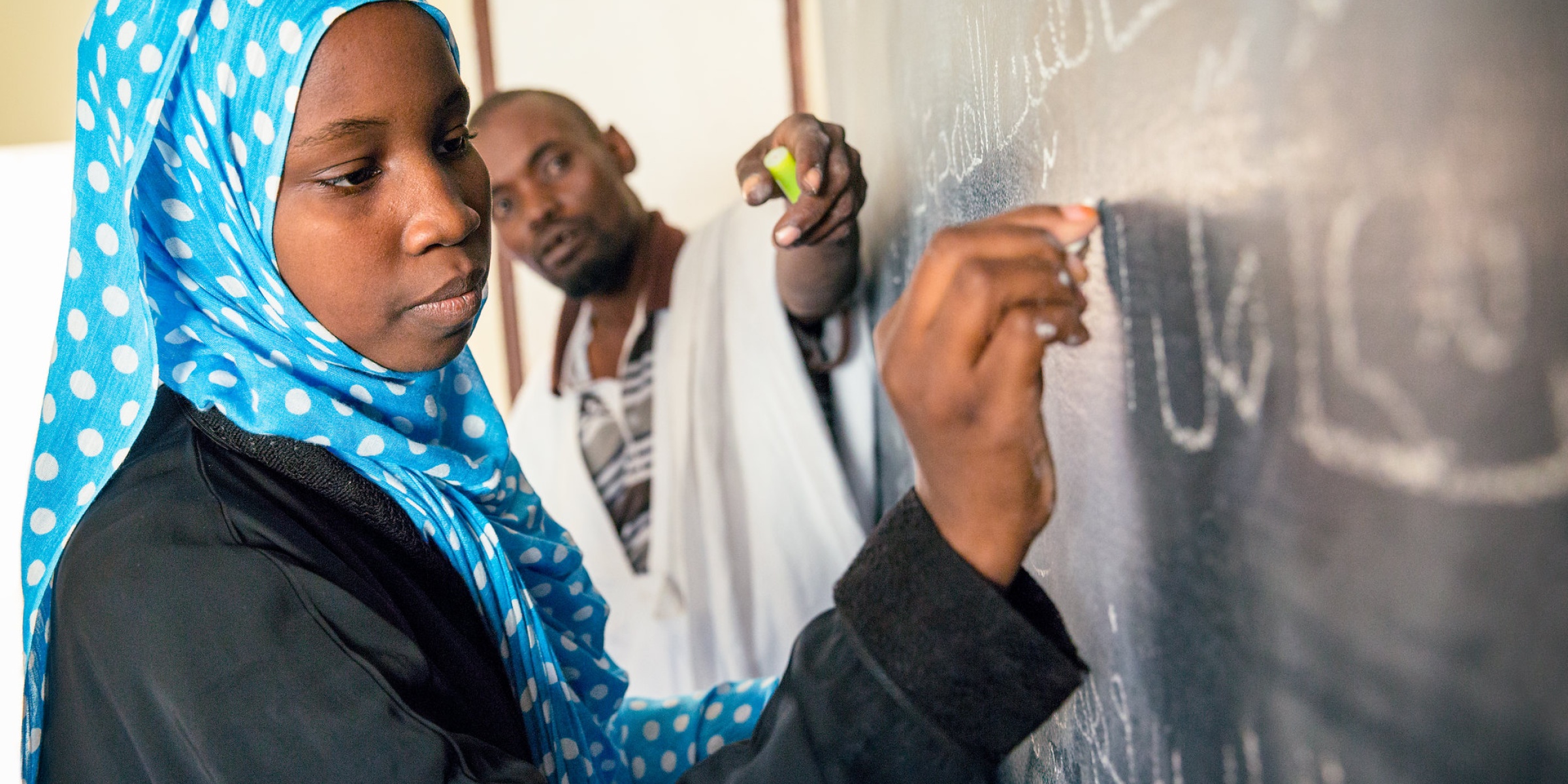 Aichetou Mint Mohamed Ali, 14, in class with teacher and Headmaster Ballaaf Ould Salem Vall; College Riyad 5, Tarhil, Nouakchott, Mauritania. Credit: GPE/Kelley Lynch